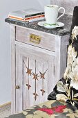 Cup on vintage bedside cabinet with marble top