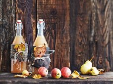 Swing-top bottles of apple juice with autumnal decorations