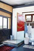 Rustikale Duschecke mit Glastrennwand und Vintage Werbeschild im Bad