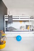 Minimalist teenagers' bedroom with white bunk beds, grey wallpaper and yellow and blue accents