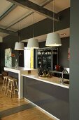Pendant lamps above counter and breakfast bar with glossy fronts