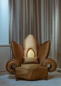 Extravagant flower-shaped armchair with gold upholstery in front of floor-length curtain
