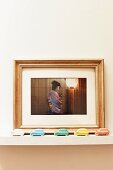 Framed photo of geisha behind toy cars of various colours on shelf