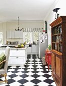 Chequered floor, rustic cabinets and old bookcase in open-plan kitchen