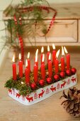 Festive arrangement of red candles and baubles