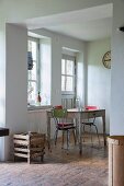 Blick durch breiten Durchgang auf Küchentisch und Vintage Stühle