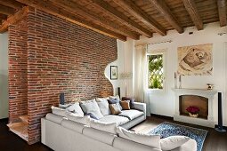Sofa set against brick wall and potted plant in disused fireplace