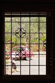 View of brightly painted car through window with metal lattice