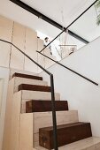 Custom staircase made from pale wood, dark wooden blocks and minimalist metal handrail