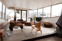 Brown sofa set, arc lamp and retro cowhide armchair in comfortable houseboat lounge area