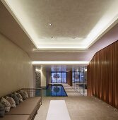 Long interior with swimming pool and mirrored wall in minimalist, luxurious ambiance