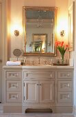 Elegant, romantic washstand below opulent, country-house-style mirror