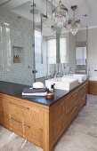 L-shaped washstand counter with solid-wood base cabinet in front of elegant, glazed shower area