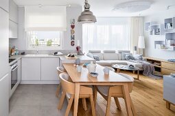 Fitted kitchen with integrated dining area and adjoining living area in shades of pale grey