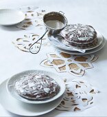 Gingerbread decorated with icing sugar on white tablecloth with cut-out patterns