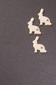 Three festive, rabbit-shaped biscuits on grey surface