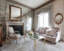 Antique furniture and fireplace in mirrored wall in luxurious interior