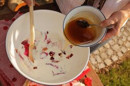 Making a milk bath with rose petals and honey