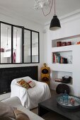 Wohnzimmerbereich mit Hussensessel, Couchtisch und dekorativen Wandnischen