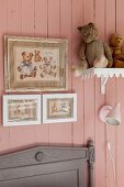 Bilder von Teddybären und Kuscheltiere auf dem Regal an rosafarbener Bretterwand