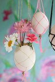 Small flowers in blown Easter egg in macrame holder