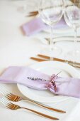 Zartviolette Stoffserviette mit Lavendelzweig auf festlichem Gedeck