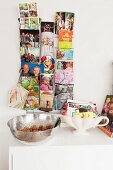 Postcards and family photos in card rack and business cards in soup tureen