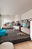 Corner sofa on platform covered in long-pile rug in small living room in shades of brown and blue