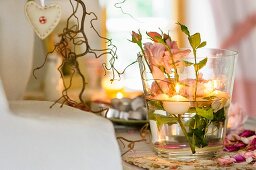 Tischdeko im Glas mit Rosen und Schwimmkerzen