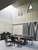 Geometric forms in dining room with concrete walls and dark furniture