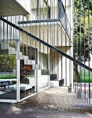 Floating metal staircase with straight balusters outside architect-designed house