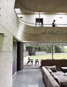 Living room with concrete gallery and walls and view of garden