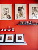 Collections of artworks on shelves and pictures on deep orange wall