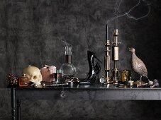 Various accessories and ornaments in charcoal-grey, Gothic ambiance (skull candlesticks, high-heels, bird figurines etc.)