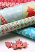 Verschiedene Geschenkpapierrollen und beklebte Wäscheklammern mit Zahlen für Adventskalender