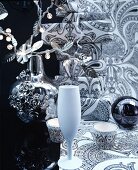 Christmas arrangement of crockery, vase, fairy lights & wrapped gifts in black and white