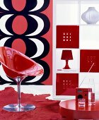 Retro living area with red shell chair and white shelving unit with open fronts and red and white fronts