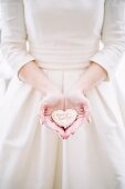 Bride holding heart-shaped wedding pastry