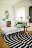 Modern chaise, standard lamp and antique side table on striped rug in front of firewood storage compartment
