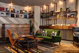 Fifties-style, retro seating area with coffee table on brightly striped rug and books and records on illuminated modular shelving