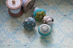 Furniture knobs with crocheted covers on surface with vintage pattern