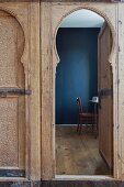 Blick durch offene, marokkanische Holztür auf Schreibplatz