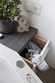 A custom-made cupboard with a pull-out laundry basket