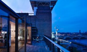 Twilight on roof terrace of penthouse apartment with view of the river Thames