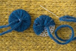 Buttons being made with the blue alpaca mixed yarn