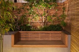 Custom, modern concrete bench with wooden seat, integrated raised bed and wooden screens