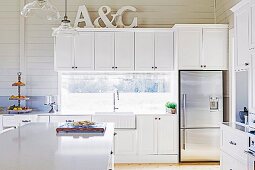 White fitted kitchen with decorative letters on wall cupboards