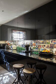 Black glossy kitchen cupboards with photos on splashback