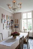 Gallery of pictures in dining room with Venetian-style glass chandelier