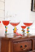 Various glasses with stems decorated with uninflated balloons